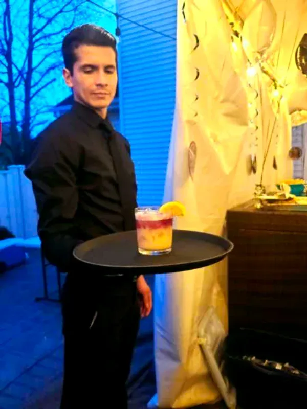 Professional staff server holding a tray in a private event NJ